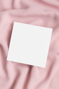 Yumuşak pembe bir tekstil üzerinde davetiye kare modeli.