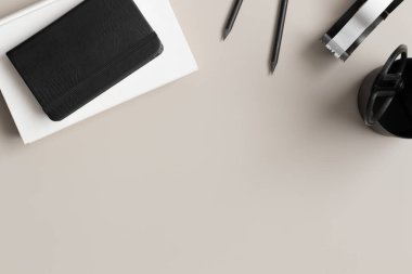 Çalışma alanı aksesuarları ve bej bir masada beyaz bir kitap. Boş kopya alanı ile düz yatıyordu.