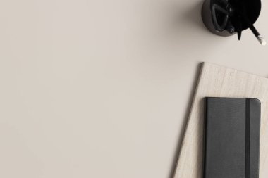 Çalışma alanı aksesuarları ve bej bir masanın üzerindeki not defterleri. Boş kopya alanı ile düz yatıyordu.