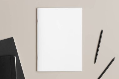 Bej masasında çalışma alanı aksesuarları olan dergi modeli.