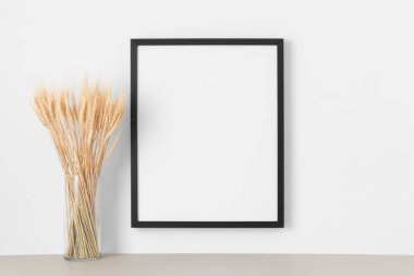 Duvarda kurumuş çiçek desenli siyah çerçeve..