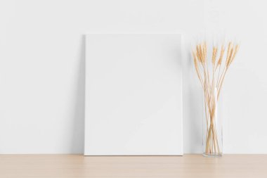 Beyaz çerçeve, ahşap masada kurumuş çiçekler..