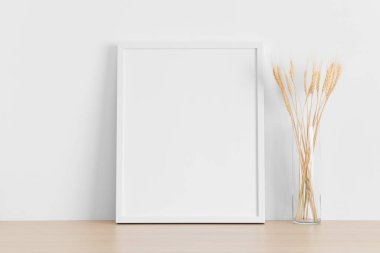 Beyaz çerçeve, ahşap masada kurumuş çiçekler..