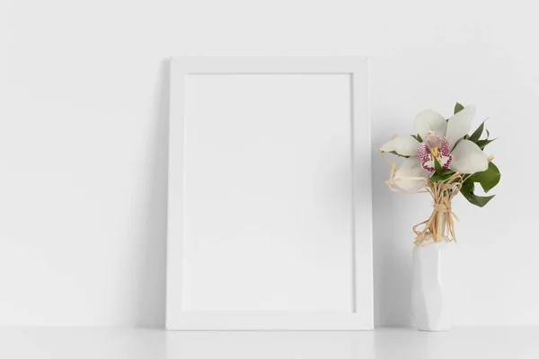 White frame mockup with a orchid on the white table.