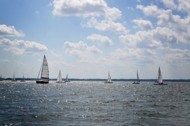 Yelkenli göl üzerinde yüzer ve mavi gökyüzü yelken açar