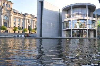 Nehir kenarındaki belediye binalarının ortasındaki kanal cam bölmeye yansıdı.