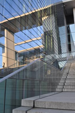 Modern ofis binası beton merdivenler cama yansıyor.