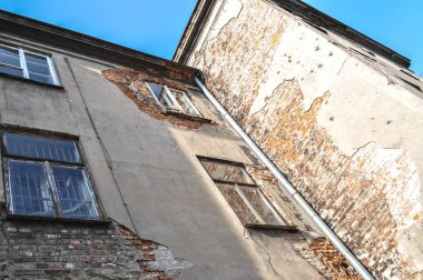 Eski binadaki pencereler harabe, hasarlı tuğla duvar terk edilmiş