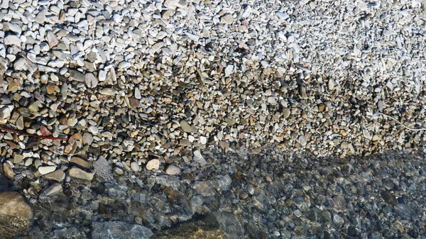 潮の干満した海の海岸の石 水との相互作用からの天然の丸みを帯びた石の様々な グラフィック天然資源として岩のビーチトップビュー — ストック写真