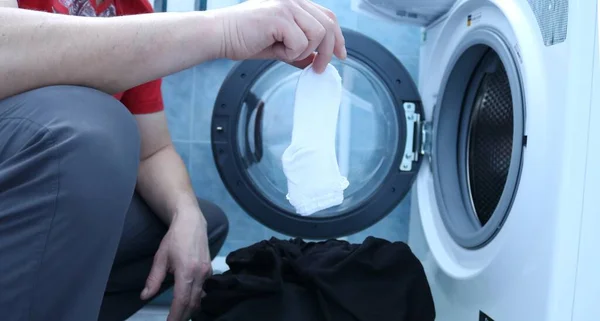 Homem Uma Camiseta Vermelha Agachando Frente Uma Máquina Lavar Roupa — Fotografia de Stock