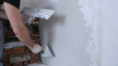 Gri desenli duvar yüzeyindeki boşluğu kopyala ve duvarı dolduran yüzü olmayan bir inşaatçı, sağdaki metin için bir bina ve bitirme süreci ve boşluk ile arkaplanı onar