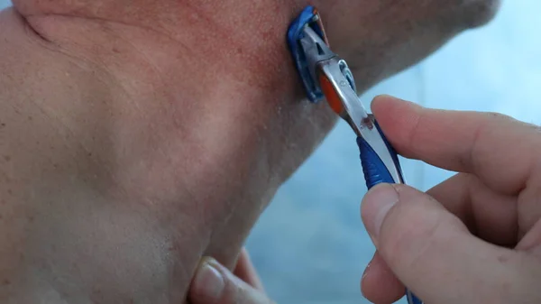 Man Shaves Blue Razor Pulling Back Skin His Neck Close — 图库照片