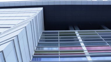 Bir şehir binasının çok renkli ön cephesinin alt görüntüsü doğrusal bir perspektifte, modern bir kentsel alanın dış görünüşü bağlamdan çıkarılmış