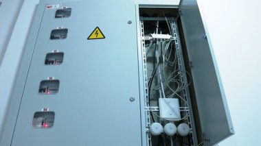 Konut binasının teknik odasındaki açık elektrik hizmet panelinin alt görüntüsü, elektrik tüketim ve iletişim kablolarının ölçüm cihazları için kurulun yapısı