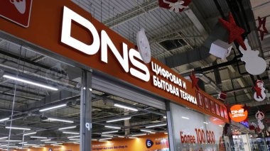 Maikop, Adygea Respublika, Rusya - 15 Şubat 2021: Alışveriş merkezinin girişinin üzerinde cam duvarlar ve tavan tasarım elementleriyle bir süpermarket DNS tabelası
