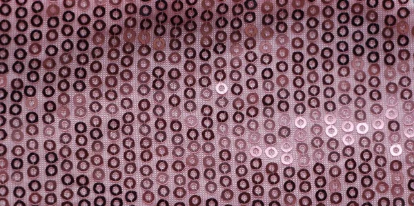 fabric pink background with shiny sequins forming a repeating pattern, sparkling design for a party and disco music look, a fragment of shimmering fabric with shining elements