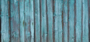 Kuru çatlaklar ve çivi ve düğümlerden oluşan desenli mavimsi boyalı eski kırsal çit, kır tarzı arka plan, kurumuş tahtalardan yapılmış eski püskü ahşap yüzey