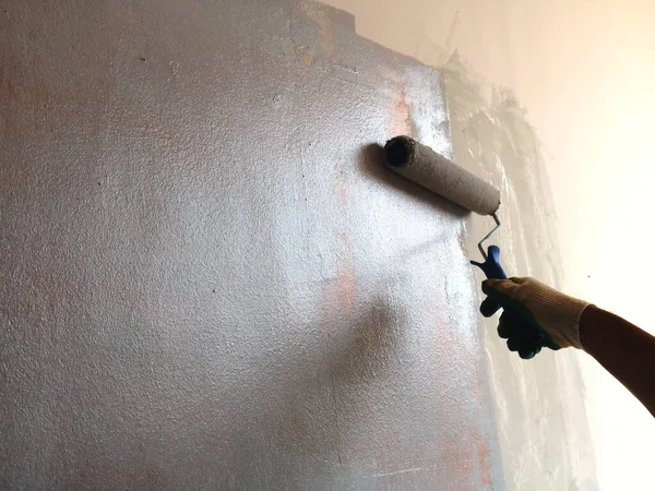 Χέρι Ένα Γάντι Ρολό Ζωγραφική Μια Υφή Γυαλιστερό Τοίχο Ένα — Φωτογραφία Αρχείου