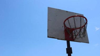 Açık mavi gökyüzüne karşı kırmızı halka ve metal zincirli ev yapımı basketbol beyaz sedyesi fotokopi alanı olan spor arka planı arka bahçede spor aktiviteleri için ekipman.