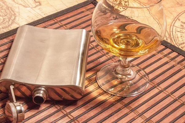 Frasco de bolsillo y un vaso con whisky —  Fotos de Stock