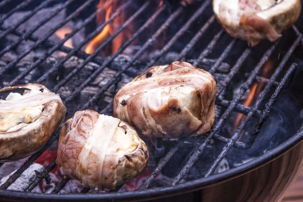 Grilling bacon wrapped, filled champignons Royalty Free Stock Images