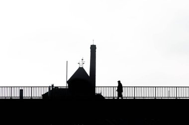 Siluetli bir adam ve binanın yüksek kontrastlı bir fotoğrafı.