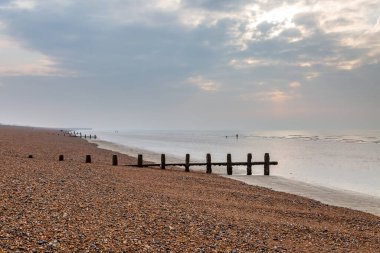 Sular çekildiğinde Sussex 'teki Shoreham-by-Sea' de çakıl taşı kumsalında ahşap damızlıklar.