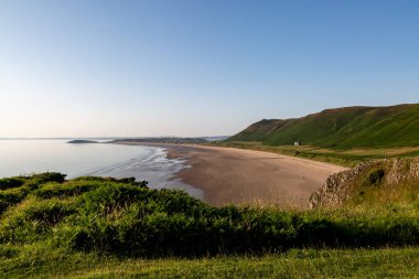 Gower Yarımadası boyunca Rhossili Körfezi 'nin engin kumlu sahillerine bakıyorum.