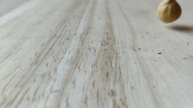 Macadamia fındıkları ahşap masaya düşüyor, ağır çekim hd. Sağlıklı kahvaltı malzemeleri. Uçan yemek..