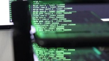 Siyah ekranda hareket eden yeşil bilgisayar yazılım kodu cama yansıyor. Raf sunucu tabanı, dinamik metin çalışan ve pc ekranında akan soyut bilgisayar hack 'leme işlemi.