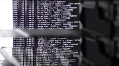 Siyah ekranda hareket eden beyaz bilgisayar yazılım kodu cama yansıyor. Raf sunucu tabanı, dinamik metin çalışan ve pc ekranında akan soyut bilgisayar hack 'leme işlemi.