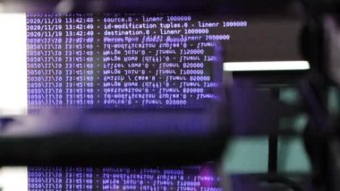 Siyah ekranda hareket eden mor bilgisayar yazılım kodu cama yansıyor. Raf sunucu tabanı, dinamik metin çalışan ve pc ekranında akan soyut bilgisayar hack 'leme işlemi.