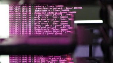 Siyah ekranda hareket eden pembe bilgisayar yazılım kodu cama yansıyor. Raf sunucu tabanı, dinamik metin çalışan ve pc ekranında akan soyut bilgisayar hack 'leme işlemi.