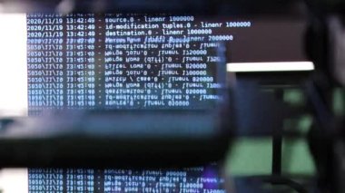 Siyah ekranda hareket eden mavi bilgisayar yazılım kodu cama yansıyor. Raf sunucu tabanı, dinamik metin çalışan ve pc ekranında akan soyut bilgisayar hack 'leme işlemi.
