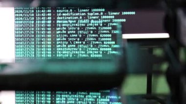 Siyah ekranda hareket eden gök mavisi bilgisayar yazılım kodu cama yansıyor. Raf sunucu tabanı, dinamik metin çalışan ve pc ekranında akan soyut bilgisayar hack 'leme işlemi.