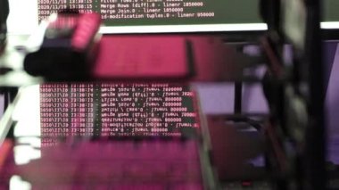Siyah ekranda hareket eden kırmızı bilgisayar yazılım kodu cama yansıyor. Raf sunucu tabanı, dinamik metin çalışan ve pc ekranında akan soyut bilgisayar hack 'leme işlemi.