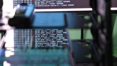 Siyah ekranda hareket eden mavi bilgisayar yazılım kodu cama yansıyor. Raf sunucu tabanı, dinamik metin çalışan ve pc ekranında akan soyut bilgisayar hack 'leme işlemi.