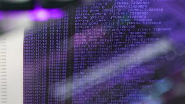 Siyah ekranda hareket eden mor bilgisayar yazılım kodu cama yansıyor. Raf sunucu tabanı, dinamik metin çalışan ve pc ekranında akan soyut bilgisayar hack 'leme işlemi.
