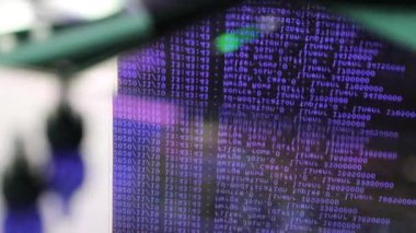 Siyah ekranda hareket eden mor bilgisayar yazılım kodu cama yansıyor. Raf sunucu tabanı, dinamik metin çalışan ve pc ekranında akan soyut bilgisayar hack 'leme işlemi.
