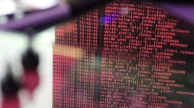 Siyah ekranda hareket eden kırmızı bilgisayar yazılım kodu cama yansıyor. Raf sunucu tabanı, dinamik metin çalışan ve pc ekranında akan soyut bilgisayar hack 'leme işlemi.