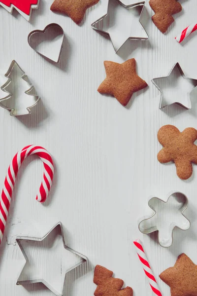 Kurabiye kesicili beyaz ahşap arka plan ve noel şekeri, mevsimlik düz yatış