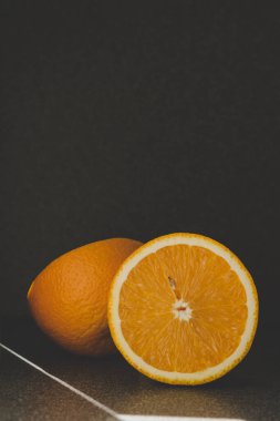 Olgun sulu portakal kesiği gri bir arka planda, arka planda