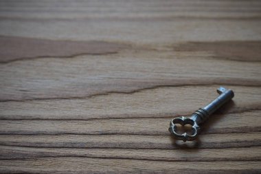 Ahşap bir masada eski moda metal bir anahtar.