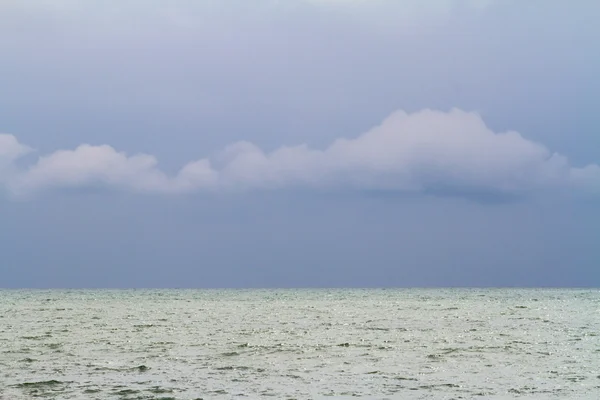 Meeresoberfläche und wolkenverhangener Himmel. — Stockfoto