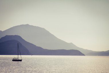 Deniz, dağlar ve balıkçı teknesi.