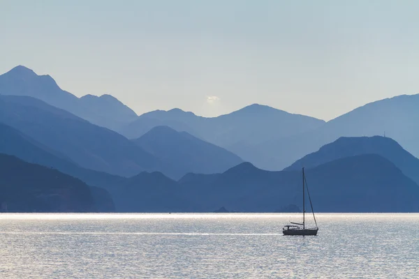 Deniz, dağlar ve balıkçı teknesi.