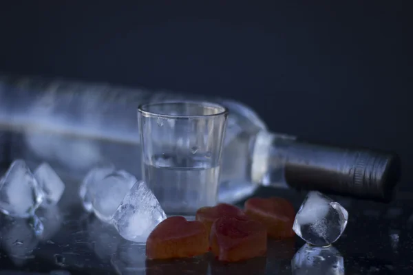 Vodka bottle with glasses and a red ice