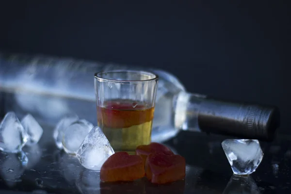 Bottiglia di vodka con bicchieri e ghiaccio rosso — Foto Stock