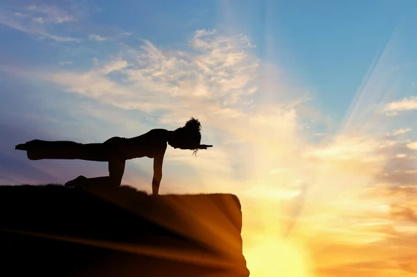 Silhuetten av en flicka som utövar yoga — Stockfoto