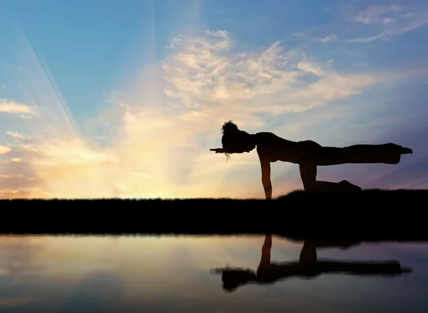 Silueta de una chica practicando yoga — Foto de Stock
